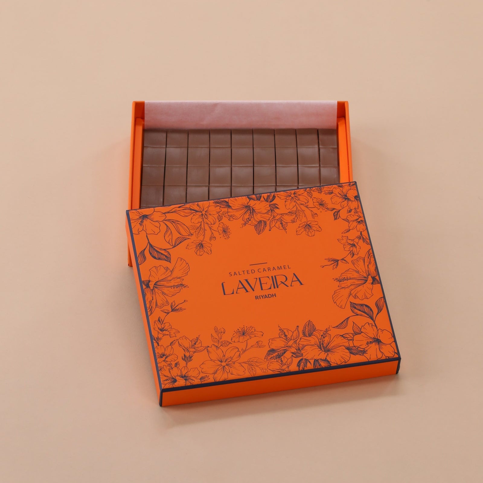 Orange Láveira chocolate packaging with a beige background