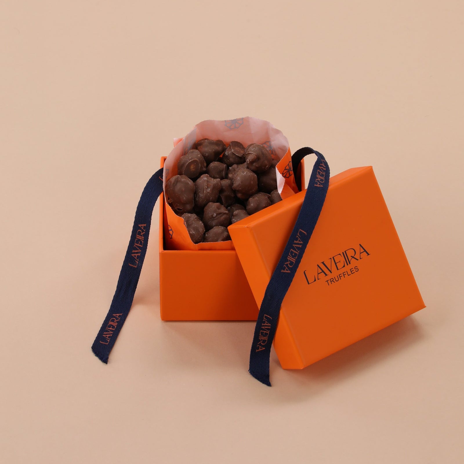 Orange box with chocolates and a blue ribbon on a beige background