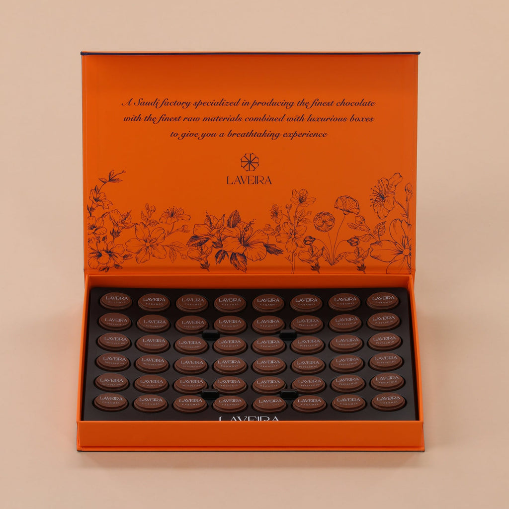 Orange chocolate box with dark chocolates on a beige background