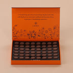 Orange chocolate box with dark chocolates on a beige background
